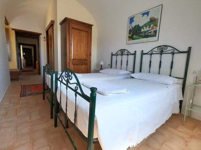 Una camera del B&B La Residenza con letto matrimoniale e lenzuola bianche